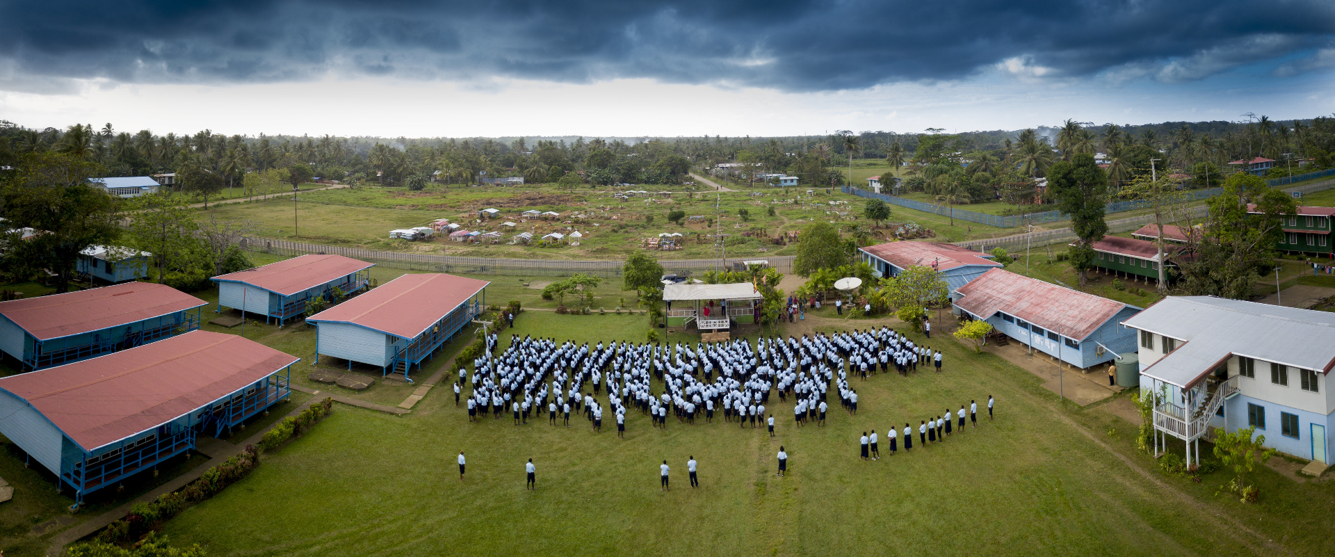 Aerial view of school assembly on a grass field
